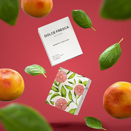 dolce fresca bath bomb by bare skin bar in grey box shown with grapefruit and basil leaf