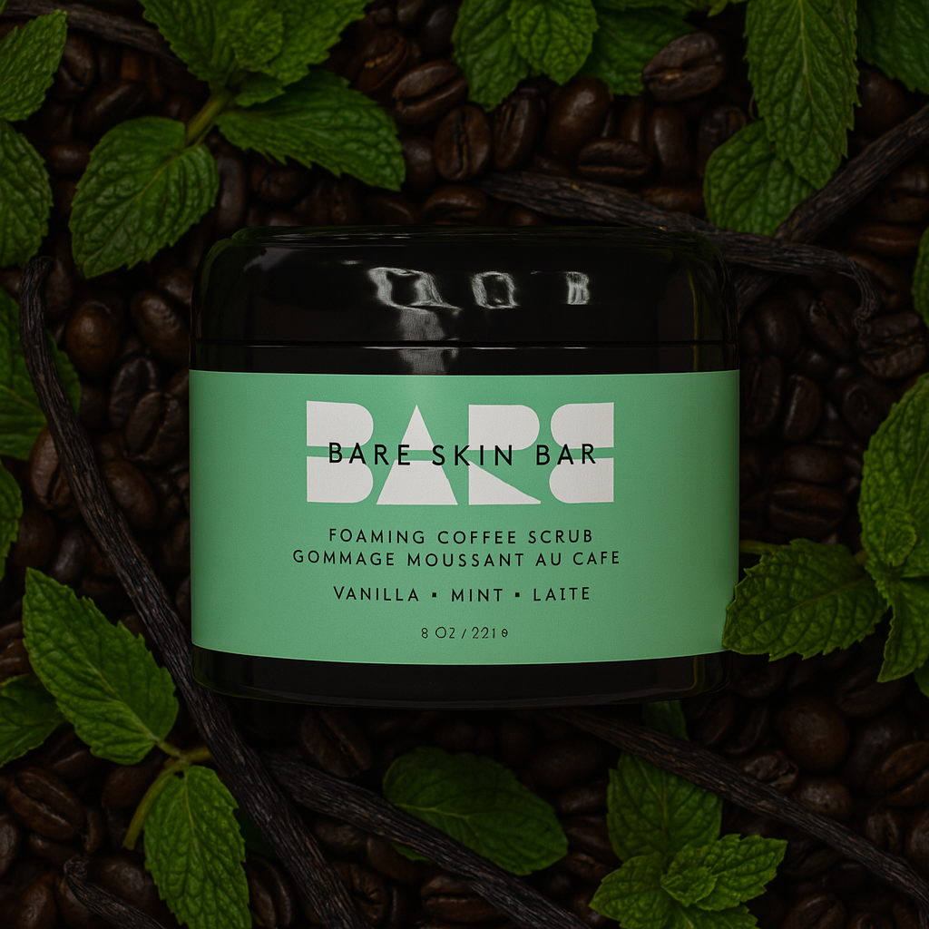 Bare Skin Bar foaming coffee scrub container with green label on a background of coffee beans and leaves.
